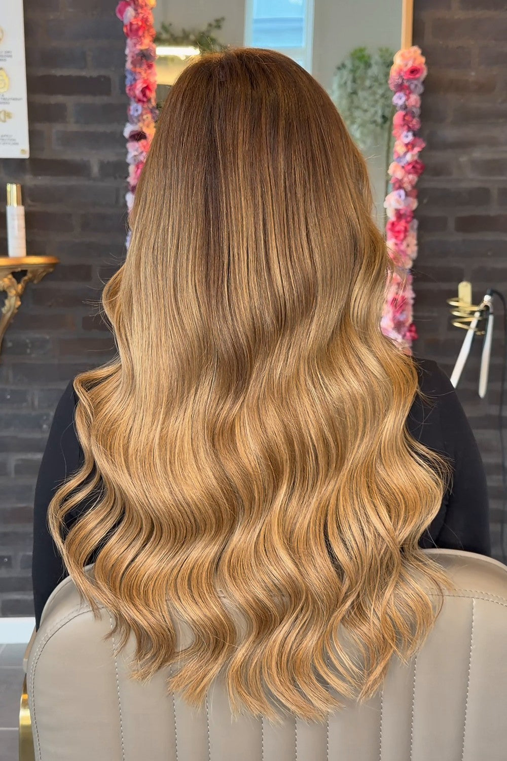 Efter: samme kunde med hair extensions, langt honningblondt hår i bløde Hollywood-bølger
