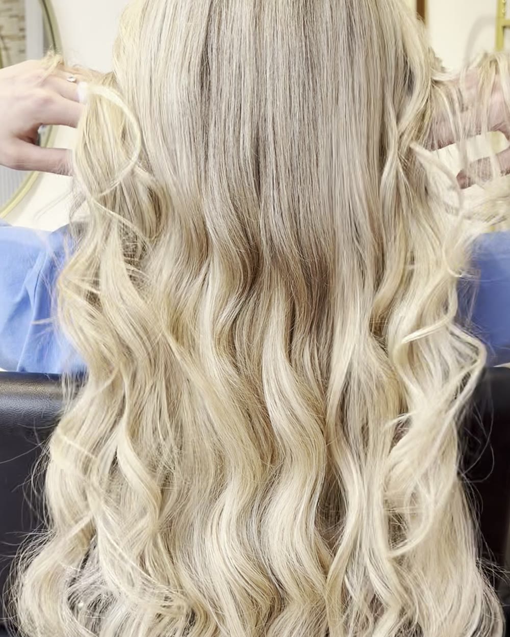 Long, wavy blonde extensions being lifted gently at the Princess Beauty salon