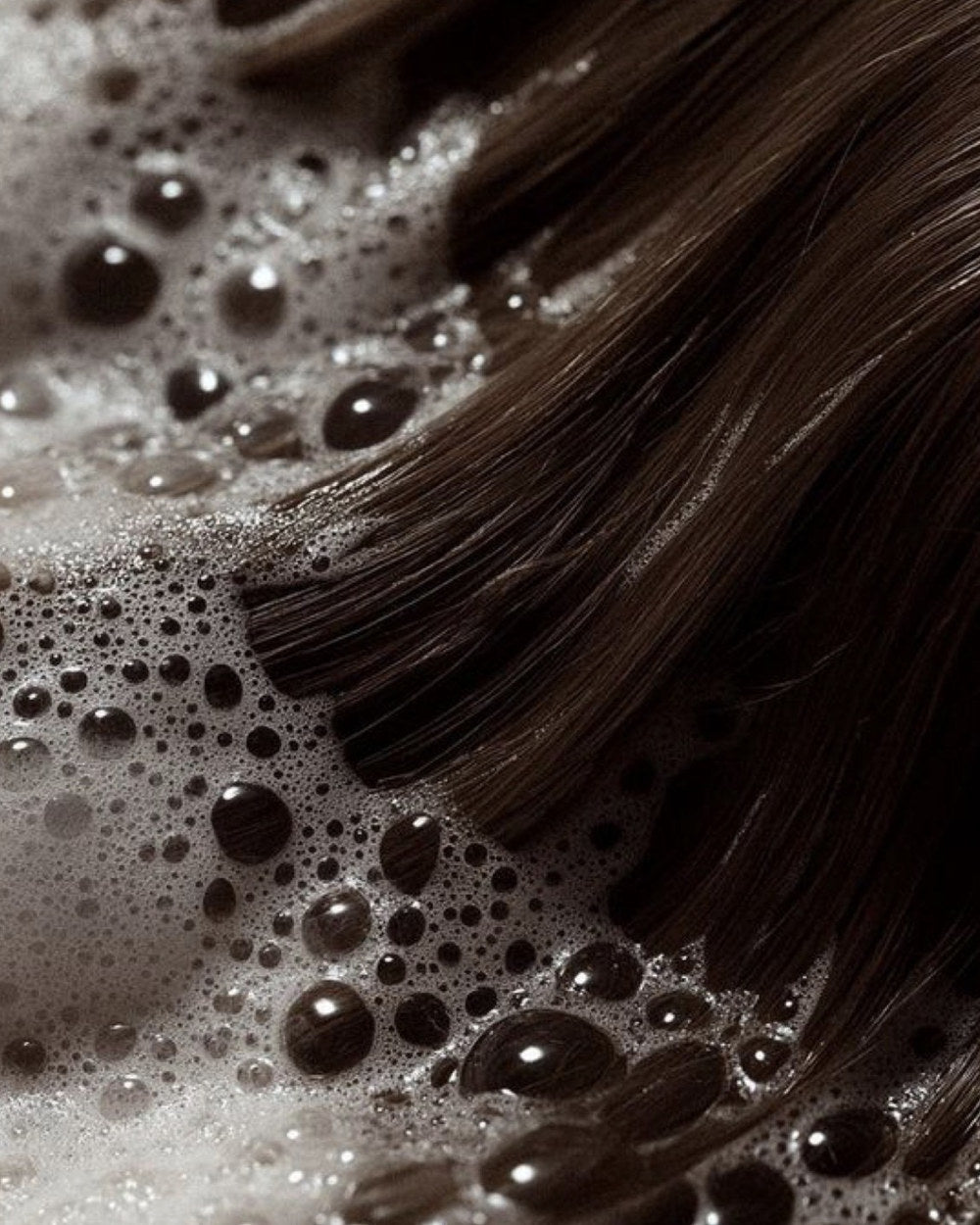 Shampooskum i langt brunt hår under hårvask